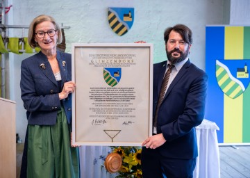 Landeshauptfrau Johanna Mikl-Leitner überreicht das Gemeindewappen an den Glinzendorfer Bürgermeister Andreas Iser-Quirgst.<br />

